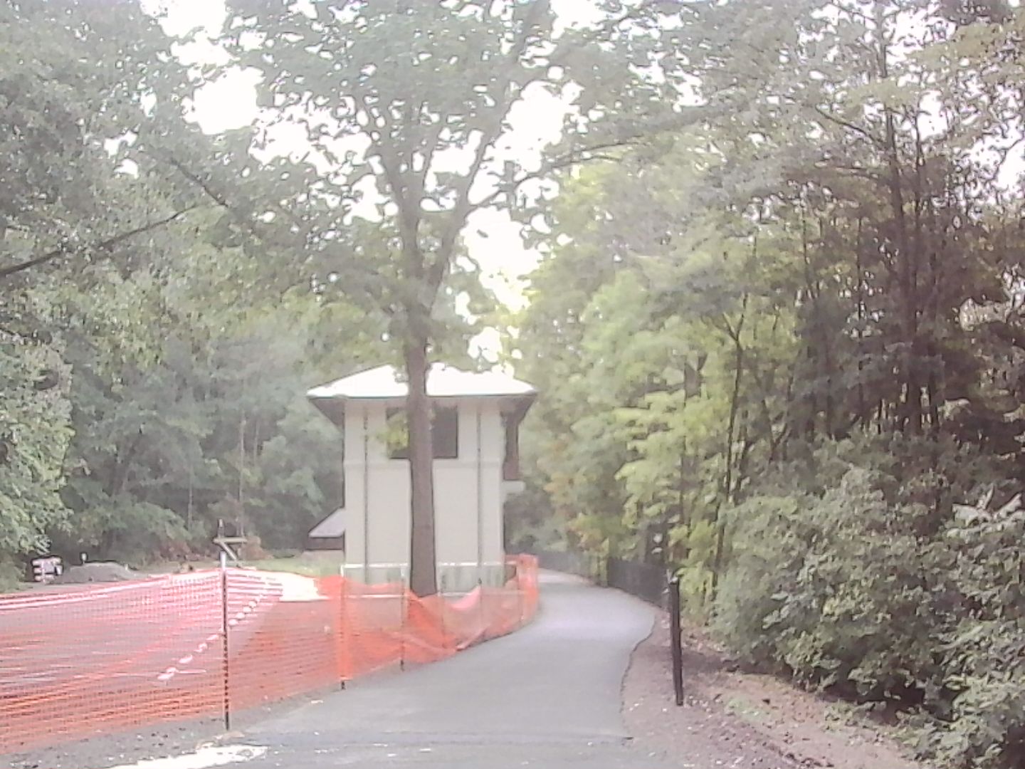 A newly paved bicycle path running next to an old railroad signal building.