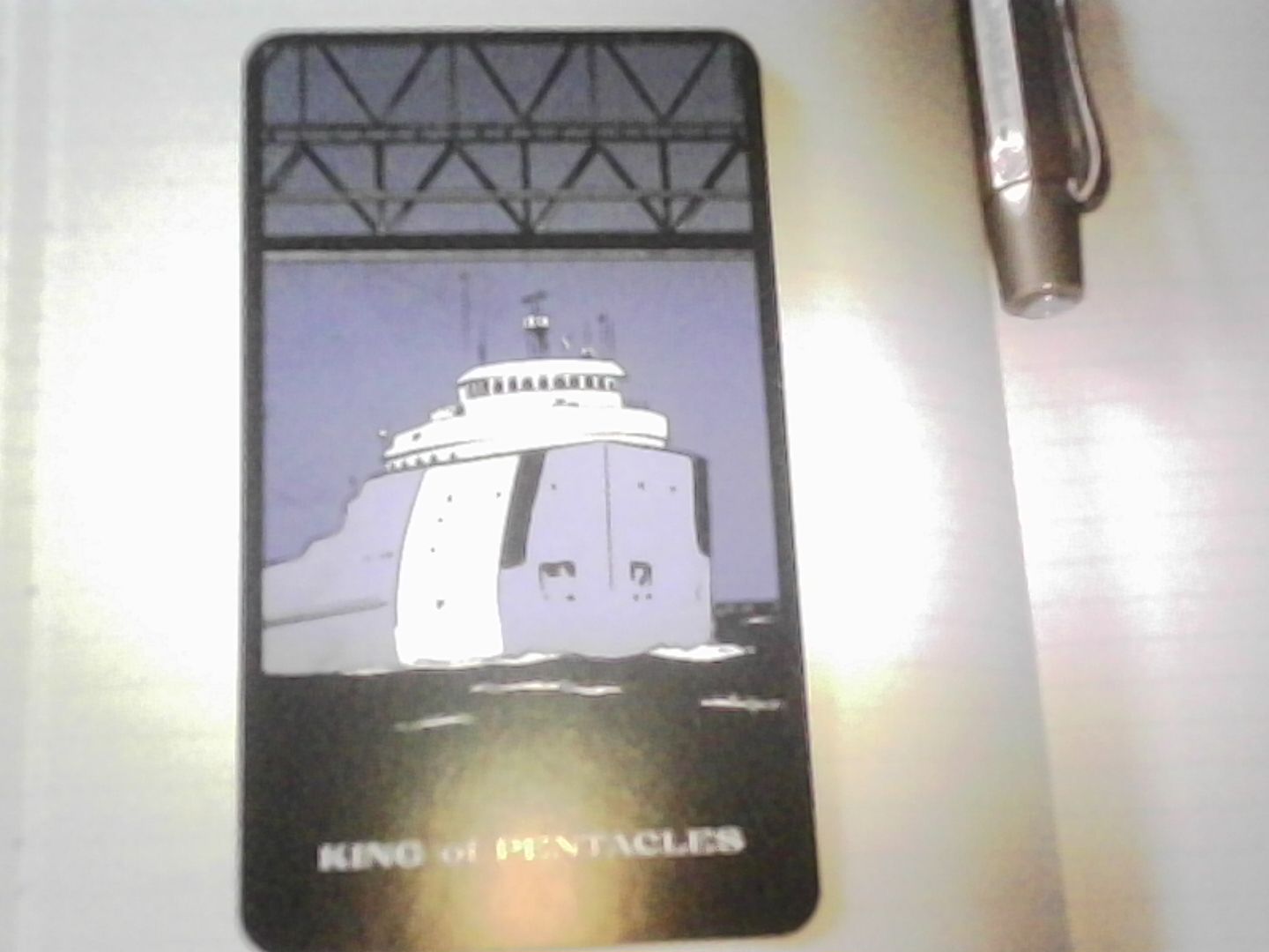 The King of Pentacles from The Great Lakes Tarot. It's The Edmund Fitzgerald at sea.