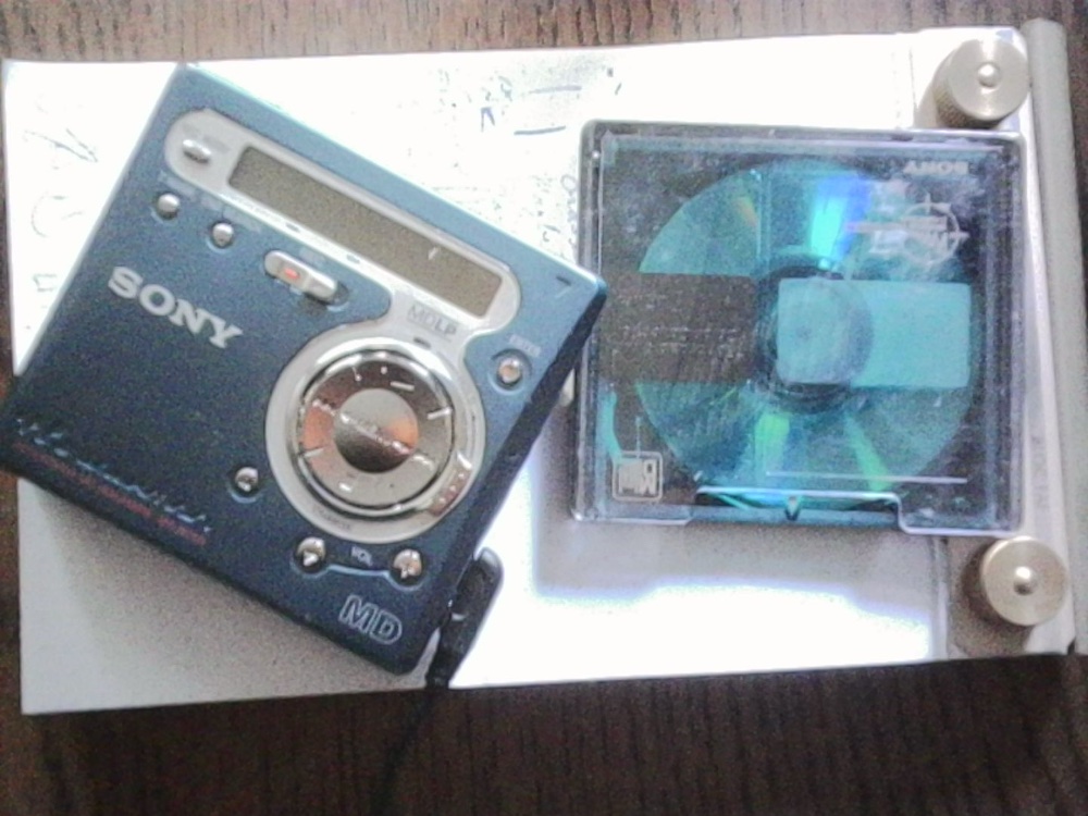 The Sony MZ-R700 MiniDisc Walkman next to a minidisc.