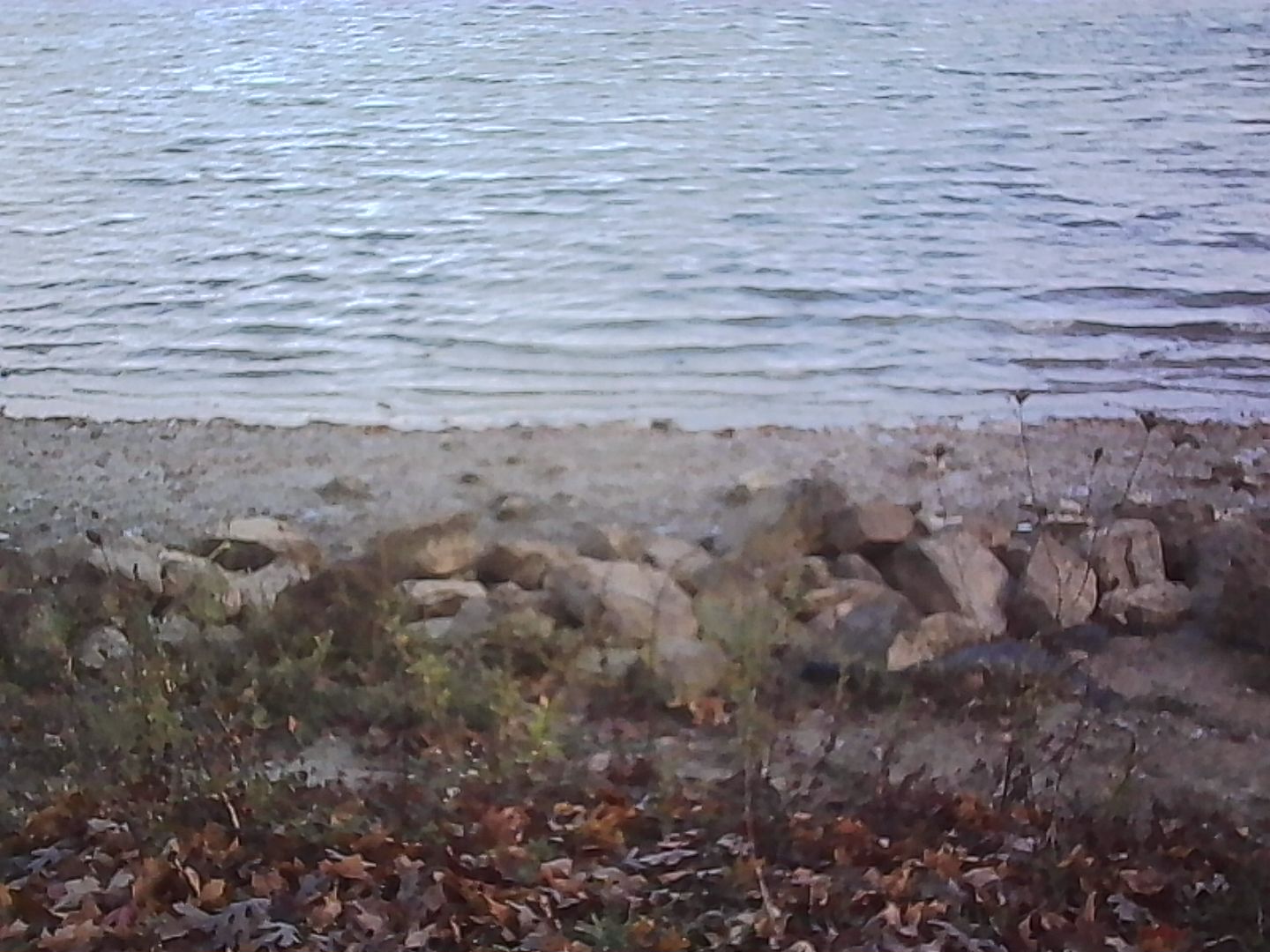Rocks along the shore that opens wide the definition of the word beach.