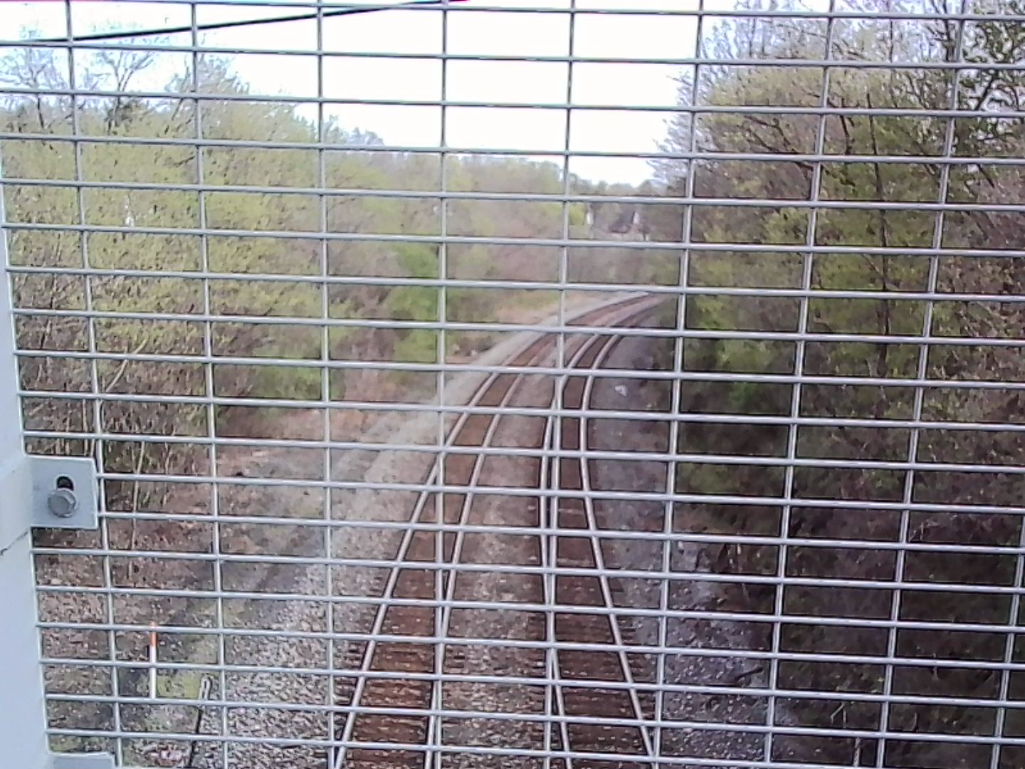 Train tracks through bridge fence. Train tracks as viewed through the fence on a different bridge