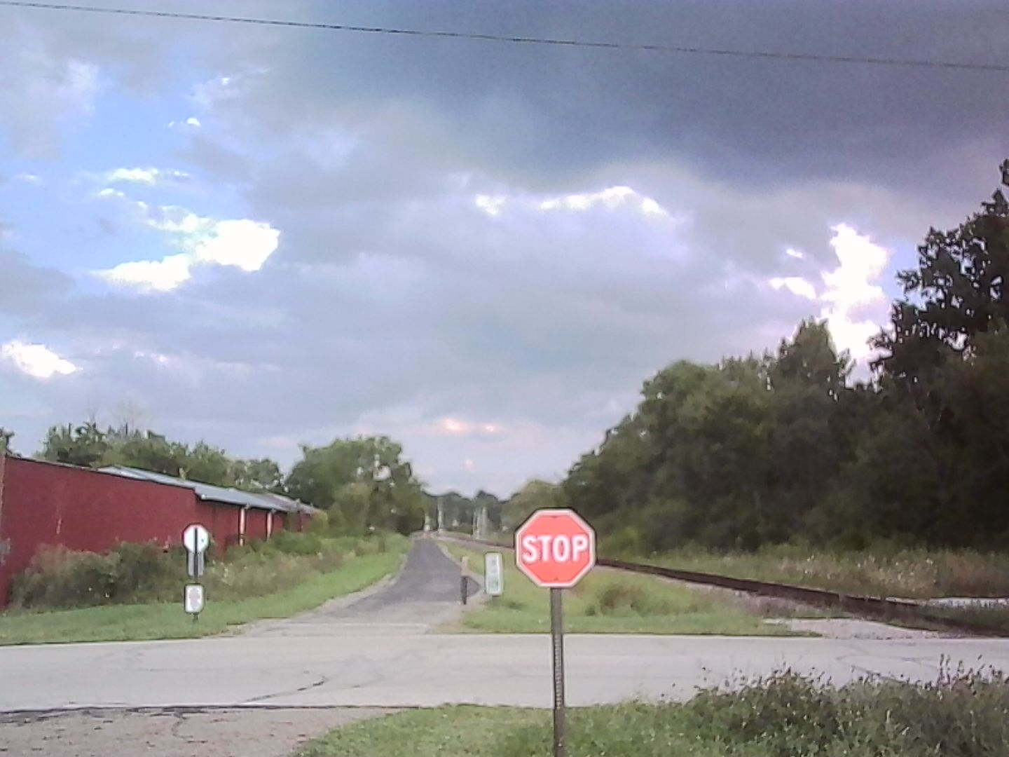 A crossroad of sorts. The hike and bike trail corsses a very quiet street. The stop sign is a lonely sentinal before a forboding sky.