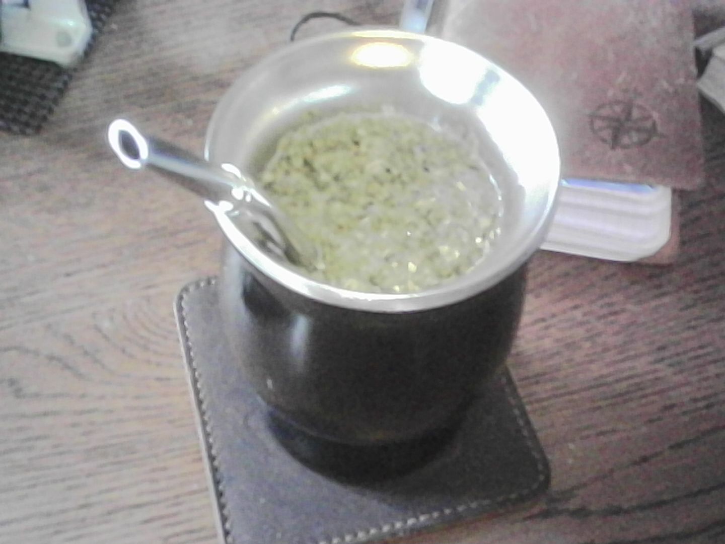 A black vessel with silver straw containing very hot Yerba Matte brewed as only a person in Ohio would brew it. Probably.