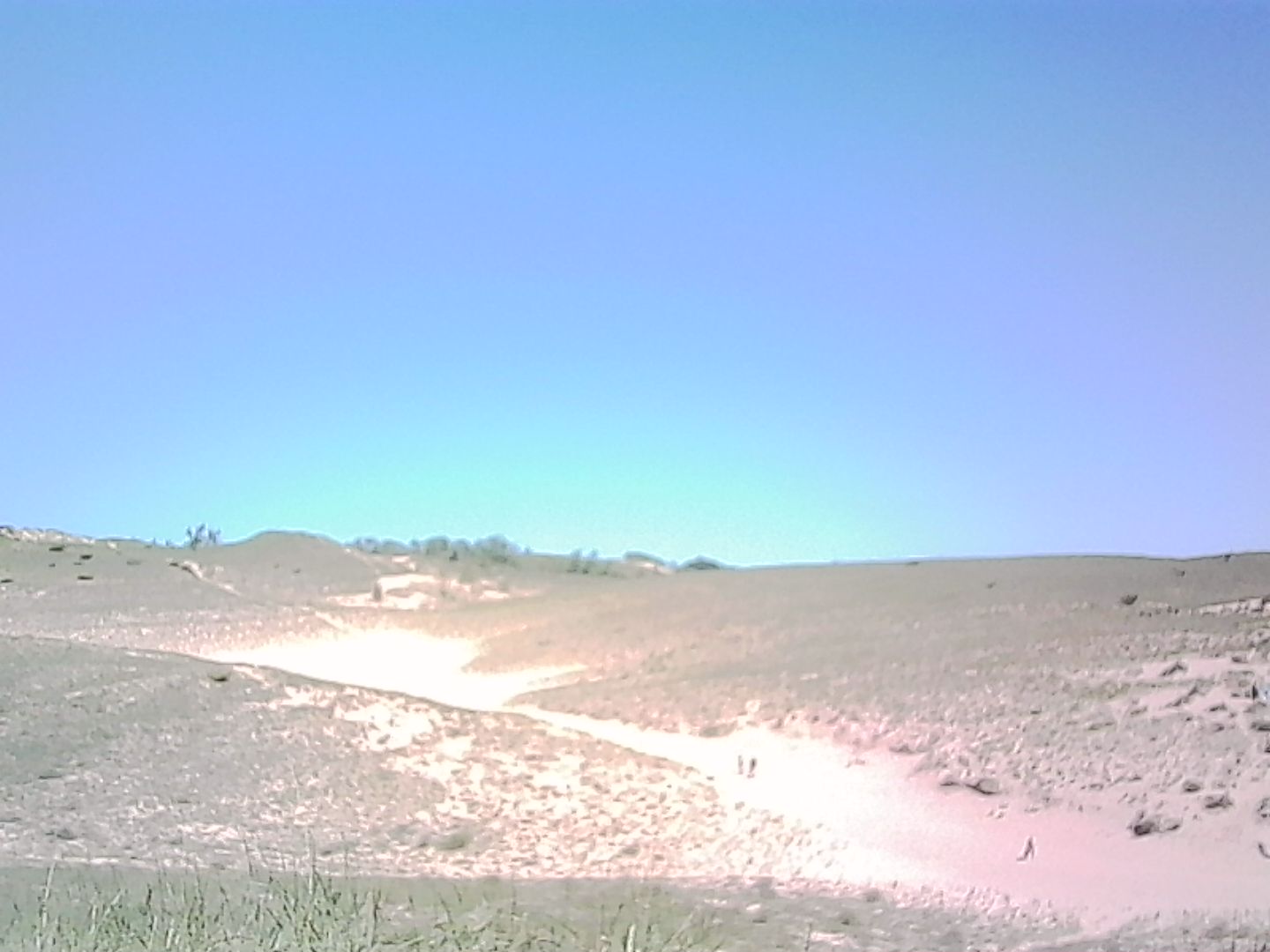 Dune crossing to Lake Michigan with people walking in the distance. Dune crossing to Lake Michigan with people walking in the distance
